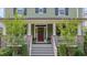 Inviting front porch with stairway, brick columns, white railings, and potted plants next to a deep red front door at 149 N Serenity Hill Cir, Chapel Hill, NC 27516