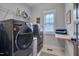 Well-equipped laundry room with modern washer and dryer, storage shelves, and a wooden folding counter at 149 N Serenity Hill Cir, Chapel Hill, NC 27516