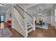 Elegant staircase leading to an open dining area with wainscoting, hardwood floors, and coffered ceiling at 149 N Serenity Hill Cir, Chapel Hill, NC 27516