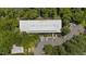 Aerial view shows a commercial building with a large, flat roof and parking lot surrounded by mature shade trees at 1500 River Mill Dr # 101, Wake Forest, NC 27587