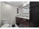 Well-lit bathroom with marble countertops, dark wood cabinets, and a modern toilet at 1500 River Mill Dr # 101, Wake Forest, NC 27587