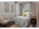 Comfortable bedroom featuring stone walls, a full bed, and a cozy chair for relaxing at 1500 River Mill Dr # 101, Wake Forest, NC 27587