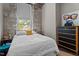 Bedroom with a full bed, stone wall accents, and a black dresser for ample storage space at 1500 River Mill Dr # 101, Wake Forest, NC 27587
