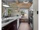 Modern kitchen featuring stone walls, stainless steel appliances, and granite countertops by bright windows at 1500 River Mill Dr # 101, Wake Forest, NC 27587
