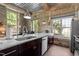 Modern kitchen featuring stone walls, stainless steel appliances, and granite countertops by bright windows at 1500 River Mill Dr # 101, Wake Forest, NC 27587