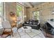 Cozy living room featuring a comfortable couch, plush rug, and unique stone wall at 1500 River Mill Dr # 101, Wake Forest, NC 27587