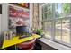 Cozy office nook with a bright yellow desk set against a stone wall and a large window with green views at 1500 River Mill Dr # 101, Wake Forest, NC 27587