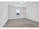 Simple bedroom featuring a modern window, a ceiling light, and neutral carpet at 1505 Willow Landing Way, Willow Springs, NC 27592