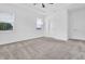 Large bedroom featuring a tray ceiling, two windows, a ceiling fan, and neutral carpet at 1505 Willow Landing Way, Willow Springs, NC 27592
