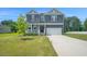 Inviting two-story home with a well-manicured lawn and a charming front porch at 1505 Willow Landing Way, Willow Springs, NC 27592