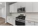 Close up view of kitchen with stainless steel range, microwave, subway tile, and white cabinetry at 156 Velvet Ridge Way, Garner, NC 27529