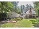 Landscaped backyard featuring a fire pit area and a two-story house with a screened-in porch and deck at 18 Clearwater Dr, Durham, NC 27707