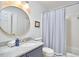Classic bathroom with a round mirror, marble countertop, and shower-tub combination at 18 Clearwater Dr, Durham, NC 27707