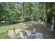 Secluded backyard firepit area surrounded by mature trees and lush landscaping at 18 Clearwater Dr, Durham, NC 27707