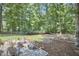 Backyard firepit area surrounded by mature trees and lush landscaping at 18 Clearwater Dr, Durham, NC 27707