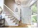 Inviting foyer featuring hardwood floors, staircase, elegant lighting and open front door at 18 Clearwater Dr, Durham, NC 27707