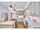 Bright kitchen featuring marble countertops, butcher block island, stainless steel appliances, and modern lighting at 18 Clearwater Dr, Durham, NC 27707