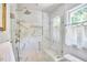Modern walk-in shower with marble tile, a bench seat, and a glass enclosure at 18 Clearwater Dr, Durham, NC 27707