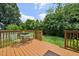 Comfortable back deck features green outdoor furniture, wood railing, and a green lawn at 1818 Misty Hollow Ln, Apex, NC 27502
