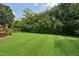 Lush green backyard featuring a well-manicured lawn and mature trees at 1818 Misty Hollow Ln, Apex, NC 27502