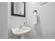Powder room featuring a pedestal sink, white towel, and decorative art at 1818 Misty Hollow Ln, Apex, NC 27502