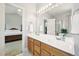 Double vanity bathroom with tile flooring, large mirror, and doorway to bedroom with bed at 1818 Misty Hollow Ln, Apex, NC 27502