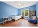 Bright blue bedroom with wood floors, ceiling fan, and a sunny window at 1818 Misty Hollow Ln, Apex, NC 27502