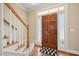 Welcoming entryway with hardwood floors, staircase, and a wooden front door with decorative glass panels at 1818 Misty Hollow Ln, Apex, NC 27502