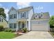 Charming two-story home with light blue siding, gray shutters, attached two-car garage, and a well-manicured front lawn at 1818 Misty Hollow Ln, Apex, NC 27502