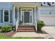 Inviting front porch with brick steps, white columns, and a gray front door with sidelights at 1818 Misty Hollow Ln, Apex, NC 27502