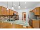 Open kitchen with a large island, wood cabinets, and stainless steel appliances at 1818 Misty Hollow Ln, Apex, NC 27502