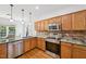 Traditional kitchen featuring oak cabinets, stainless steel appliances, and elegant stone countertops at 1818 Misty Hollow Ln, Apex, NC 27502