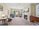Comfortable living room with a fireplace, large windows, neutral colors, and a ceiling fan at 1818 Misty Hollow Ln, Apex, NC 27502