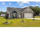 Charming single-story home with gray siding, a two-car garage and a well-manicured lawn and young trees at 19 Linda Lou Ln # 19, Angier, NC 27501