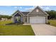 Charming single-story home with gray siding, a two-car garage and a well-manicured lawn with flower beds at 19 Linda Lou Ln # 19, Angier, NC 27501