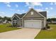 Charming single-story home with gray siding, a two-car garage and a well-manicured lawn with flower beds at 19 Linda Lou Ln # 19, Angier, NC 27501