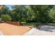 Wide wooden deck overlooking the lawn and landscape with a brick retaining wall and mature shade trees at 1926 Downing Dr, Burlington, NC 27215