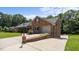 Charming brick home featuring an attached garage, manicured landscaping, and an extra parking pad at 1926 Downing Dr, Burlington, NC 27215