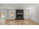 Cozy living room featuring a charming fireplace, hardwood floors, and ample natural light from the window at 1926 Downing Dr, Burlington, NC 27215