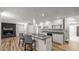 Stylish kitchen island with bar seating, modern appliances, and a view of the fireplace in the living space at 1926 Downing Dr, Burlington, NC 27215
