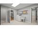 Bright laundry room with a utility sink, washer, dryer, and built-in shelving for efficient organization at 1926 Downing Dr, Burlington, NC 27215