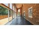 A spacious sunroom with brick walls and a wall of windows offers relaxation and outdoor living at 1926 Downing Dr, Burlington, NC 27215