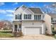 Charming two-story home boasts a white exterior, well-manicured lawn, and attached garage, perfect for comfortable living at 1968 Shadow Glen Dr, Raleigh, NC 27604