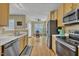 Open concept kitchen with stainless steel appliances, hardwood floors, and eat-in dining area at 1968 Shadow Glen Dr, Raleigh, NC 27604