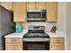 Modern kitchen with stainless steel microwave, oven, and light wood cabinets at 1968 Shadow Glen Dr, Raleigh, NC 27604