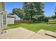 Spacious backyard with a lush green lawn, mature trees, a wooden fence, and a concrete patio at 2000 Silky Dogwood Trail Trl, Apex, NC 27502