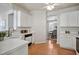 Bright kitchen area with white appliances, cabinets, wood flooring, and dining area view at 2000 Silky Dogwood Trail Trl, Apex, NC 27502
