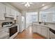 Well-lit kitchen featuring white cabinets, appliances, and a dining area view at 2000 Silky Dogwood Trail Trl, Apex, NC 27502