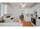 Bright kitchen featuring white appliances, cabinetry, and wood flooring at 2000 Silky Dogwood Trail Trl, Apex, NC 27502