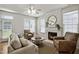 Bright living room with a fireplace, comfortable seating, and large windows offering plenty of natural light at 2000 Silky Dogwood Trail Trl, Apex, NC 27502